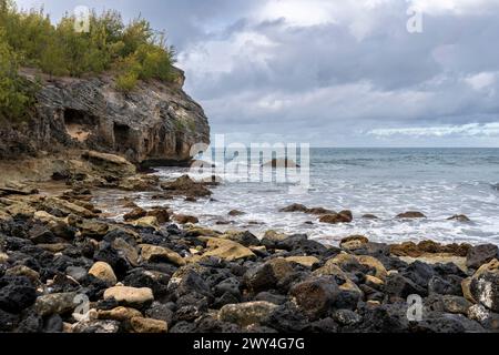 Raue Wellen des Pazifischen Ozeans krachen auf zerklüftete Klippen entlang des Shipwreck Beach in Koloa, Hawaii, auf der Insel Kauai. Stockfoto