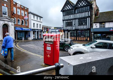 Leatherhead Surrey, UK, 03. April 2024, Woman Carry Shopping, der an Einem Royal Mail Paketkarton vorbeiläuft Stockfoto