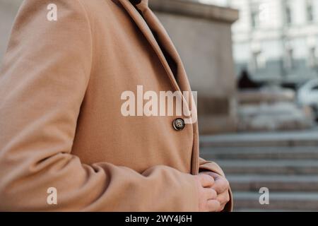 Details zum beigefarbenen braunen Männermantel. Klassische Street-Oberbekleidung Stockfoto