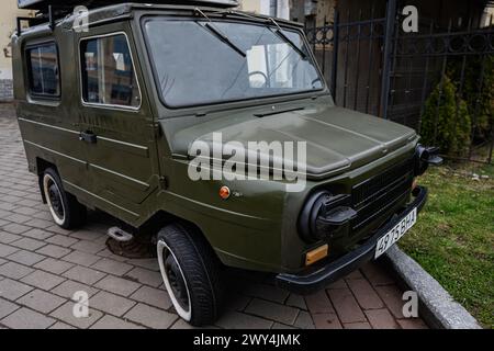 Lutsk, Ukraine - März 2024: Klassischer olivgrüner LuAZ-969 sowjetischer Mini-SUV Woljnianka mit Retro-Design auf urbanem Bürgersteig, der an Nostalgie und Nostalgie erinnert Stockfoto
