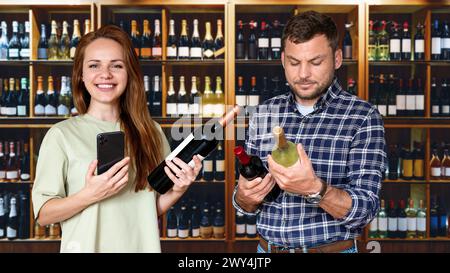 Junges erwachsenes Paar, das Wein im Spirituosengeschäft wählt. Weinhandlung und Verbraucher. Stockfoto