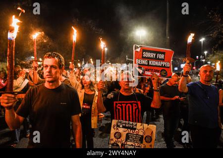 Jerusalem, Israel. April 2024. Demonstranten marschieren, während sie Fackeln und Schilder halten. Tausende Israelis versammelten sich um die Knesset, um gegen Premierminister Benjamin Netanjahu zu protestieren, gefolgt von einem fackelmarsch, der von den Familien der Geiseln geführt wurde, zu Premierminister Netanjahus Residenz in der Azza Street, wo er einen sofortigen Geiselvertrag und allgemeine Wahlen forderte. Es kam zu Auseinandersetzungen mit der israelischen Polizei um die Polizeibarriere rund um Netanjahus Haus. Fünf wurden verhaftet, darunter ein Demonstrant, der unter eine Polizeikanone legte, die sie am Betrieb hinderte. Quelle: SOPA Images Limited/Alamy Live News Stockfoto