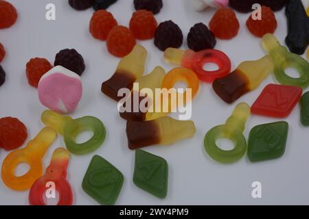 Süßigkeiten in Form eines schwarzen Autos, Himbeeren, Brombeeren, Cola-Flaschen, farbige Schlüssel, Diamanten mit dem Alphabet. Stockfoto