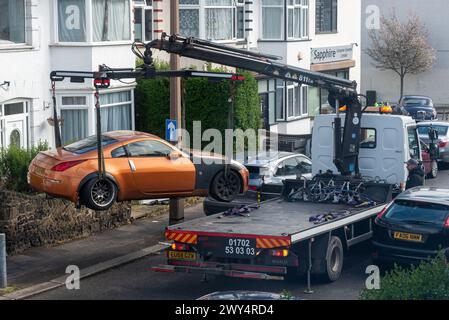 Beschädigtes Auto wird von einem Pannenwagen in einer engen Straße in Essex, Großbritannien, geborgen Stockfoto