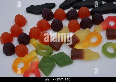 Süßigkeiten in Form eines schwarzen Autos, Himbeeren, Brombeeren, Cola-Flaschen, farbige Schlüssel, Diamanten mit dem Alphabet. Stockfoto