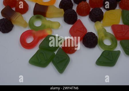 Süßigkeiten in Form eines schwarzen Autos, Himbeeren, Brombeeren, Cola-Flaschen, farbige Schlüssel, Diamanten mit dem Alphabet. Stockfoto