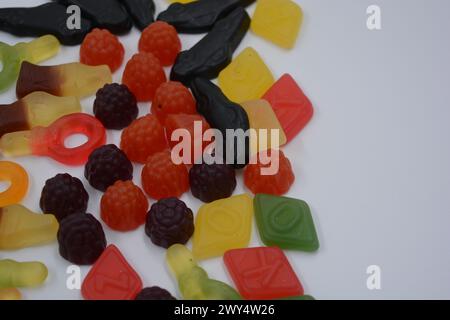 Süßigkeiten in Form eines schwarzen Autos, Himbeeren, Brombeeren, Cola-Flaschen, farbige Schlüssel, Diamanten mit dem Alphabet. Stockfoto