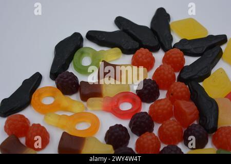 Süßigkeiten in Form eines schwarzen Autos, Himbeeren, Brombeeren, Cola-Flaschen, farbige Schlüssel, Diamanten mit dem Alphabet. Stockfoto