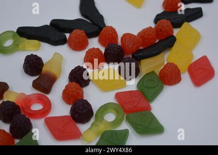 Süßigkeiten in Form eines schwarzen Autos, Himbeeren, Brombeeren, Cola-Flaschen, farbige Schlüssel, Diamanten mit dem Alphabet. Stockfoto