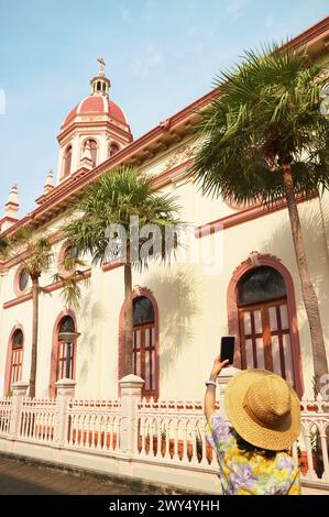 Weibliche Besucherin fotografiert die Santa Cruz Kirche, eine bekannte altkatholische Kirche in Kudi Chin Viertel in Bangkok, Thailand Stockfoto