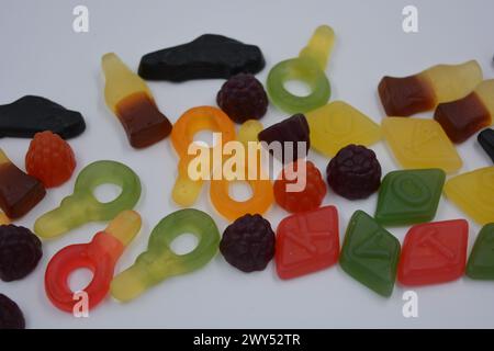 Süßigkeiten in Form eines schwarzen Autos, Himbeeren, Brombeeren, Cola-Flaschen, farbige Schlüssel, Diamanten mit dem Alphabet. Stockfoto