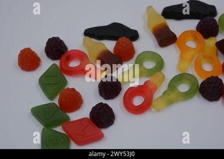 Süßigkeiten in Form eines schwarzen Autos, Himbeeren, Brombeeren, Cola-Flaschen, farbige Schlüssel, Diamanten mit dem Alphabet. Stockfoto