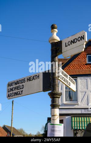 Wegweiser im alten Stil im Dorf Balcombe mit Wegbeschreibungen zu verschiedenen Städten. West Sussex, England. Stockfoto