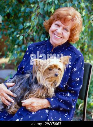 Brigitte Mira, deutsche Volksschauspielerin, Chansonsängerin und Kabarettistin, bei einem Fotoshooting mit Yorkshire Terrier im Garten zuhause in Berlin, Deutschland um 1993. Stockfoto