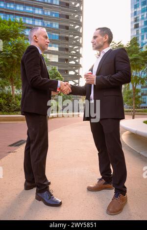 Zwei lächelnde Geschäftsleute schütteln nach erfolgreichem Meeting die Hand. Stockfoto
