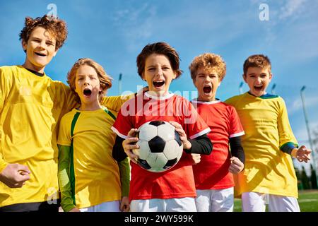 Eine vielfältige Gruppe junger Menschen steht zusammen und bildet einen Kreis, jeder hält einen Fußball. Sie lächeln und wirken enthusiastisch und uni Stockfoto