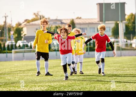 Eine lebhafte Szene entfaltet sich, während eine Gruppe von jungen Jungs energisch um einen Fußball herumkippt und ihre Fähigkeiten und Leidenschaft für das Spiel auf einem Gras zeigt Stockfoto