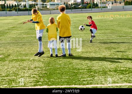 Eine vielfältige Gruppe kleiner Kinder, voller Energie und Begeisterung, nimmt aktiv an einem Fußballspiel Teil. Sie laufen, treten, passieren, Stockfoto