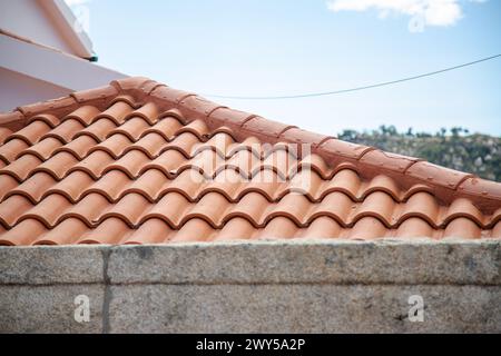 Orangefarbene Fliesen auf einem Dach mit Steinmauern. Kopierbereich Stockfoto