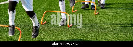 Eine Gruppe von Fußballspielern in ihren Mannschaftsuniformen steht triumphierend auf einem üppig grünen Fußballfeld, vereint in Feiern und Siegen. Stockfoto