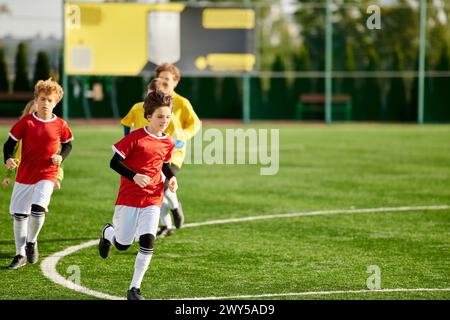 Eine Gruppe kleiner Jungs spielt enthusiastisch Fußball, rennt herum, tritt den Ball und jubelt sich in einem freundlichen Wettkampf an Stockfoto