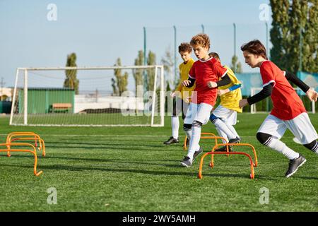 Eine lebhafte Gruppe von Jungen, die sich an einem Wettkampf-Fußballspiel beteiligen, laufen, treten und den Ball auf einem pulsierenden Feld weitergeben. Stockfoto