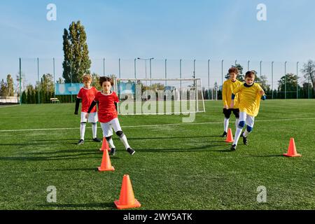 Eine Gruppe von Jungen, die begeistert Fußball auf einem grünen Feld spielen. Sie dribbeln, passieren und schießen den Ball mit Begeisterung und Freude. Stockfoto