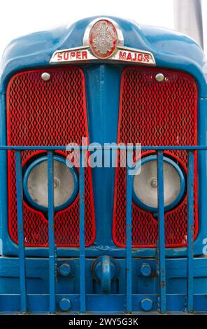 Vorderansicht des Kühlergrills eines alten Super Major-Traktors, rot und blau lackiert Stockfoto