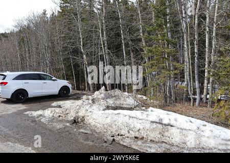 Ein großes weißes Auto auf einem schneebedeckten Parkplatz Stockfoto