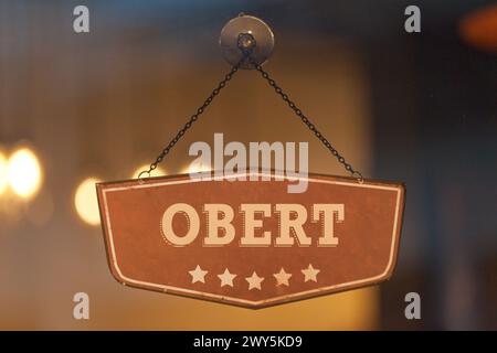 Altmodisches Schild im Fenster eines Ladens mit der Aufschrift auf Katalanisch 'Obert', was auf Englisch 'Open' bedeutet. Stockfoto