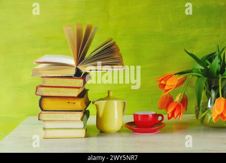 Stapel Bücher mit offenem Buch, Tasse Espresso und ein paar Blumen, Lesen, Lernen, neue Buchveröffentlichungen für Sommer und Urlaub, Wissen Stockfoto