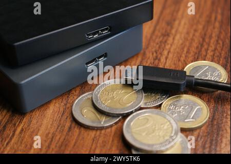 Externe Festplatte mit Nahaufnahme des Kabels. Externe Festplatten und Euro-Münzen. Stockfoto