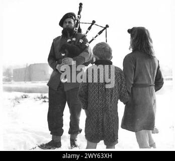 5. SEAFORTH HIGHLANDERS PFEIFENBAND - Pipe-Major Gordon Asher von Halkirk, Caithness, der berühmte bärtige Piper, der seit fünf Jahren Pipe-Major der BN ist und sie auf halbem Weg um die Welt gespielt hat, ist nicht bestürzt von der Neugier zweier belgischer Kinder, die ihm die Leitung der Band zuhören. Britische Armee, 21. Armeegruppe Stockfoto