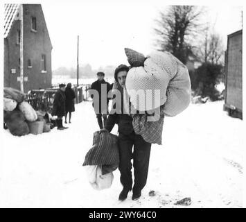 DEUTSCHLAND ZAHLT DEN PREIS IM "SITTARD-DREIECK" - Ein deutscher Zivilist trägt einige seiner Sachen in sein neues Zuhause in Tuddern. Britische Armee, 21. Armeegruppe Stockfoto