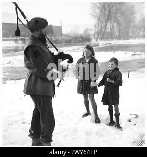 5TH SEAFORTH HIGHLANDERS PIPE BAND - Ausdrücke auf den Kindergesichtern, während sie Pipe-Major Gordon Asher durch die Pfeife des Pipers im Vorderboden sehen. Britische Armee, 21. Armeegruppe Stockfoto