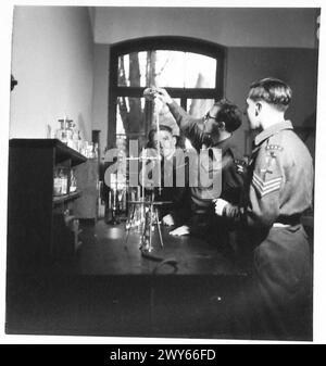 KOLLEGIUM DER RHEINARMEE - Sergeant Butler, C.G. von Braadford. Wissenschaftslehrer, der am Bradford Technical College war und die B.Pharmacy der London University hat, zeigt L/Corporal C.Wood of York, der vor dem Krieg ein Lithografie-Drucker war, das Geheimnis der guten Tritation. , Britische Rheinarmee Stockfoto