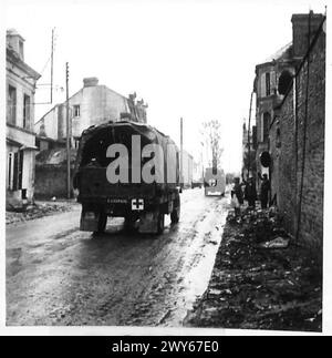 11. GEPANZERTE DIV. FAHREN SIE AN ARGENTAN VORBEI - während britische Fahrzeuge Argentan passieren, stehen die französischen Zivilisten im Regen heraus und winken den befreienden Truppen zu. Britische Armee, 21. Armeegruppe Stockfoto