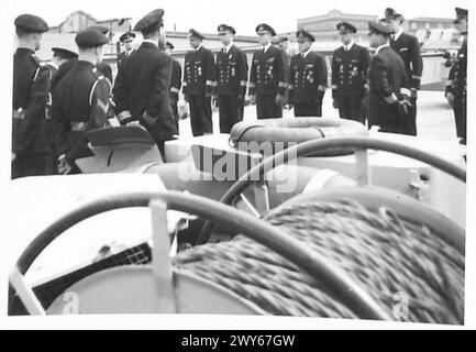 BRITISCHE MARINEOFFIZIERE INSPIZIEREN DEUTSCHE KREUZER – britische Marineoffiziere stellten sich gegenüber deutschen Marineoffizieren auf, während ihnen Anweisungen vorgelesen werden. Britische Armee, 21. Armeegruppe Stockfoto