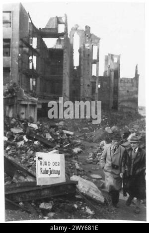 DIE PRODUKTION Einer ZEITUNG IN DEUTSCHLAND - Richard Kraske Chefreporter und Fotograf Heer Frederick Schley, der die Potgasse auf dem Weg zum Büro hinuntergeht. Auf dem Schild links steht „zum Büro der Ruhr Zeitung“. , Britische Rheinarmee Stockfoto