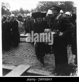 ZEREMONIELLE BEERDIGUNG DER BRÜSSELER POLIZEI, ERSCHOSSEN VON DEN DEUTSCHEN - einer der Familie, der Blumen ins Grab wirft, britische Armee, 21. Armeegruppe Stockfoto