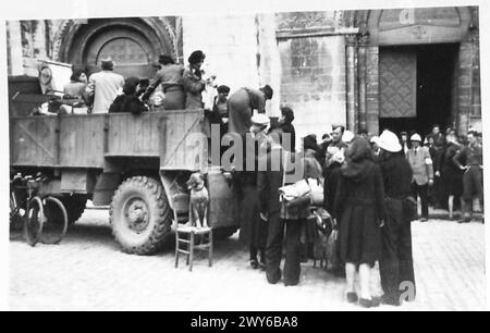 EVAKUIERUNG DER MENSCHEN VON CAEN - Frauen der französischen Militärmission Verbindungsstelle, die gute Arbeit leisten, helfen Flüchtlingen mit ihrem Gepäck auf LKW. Britische Armee, 21. Armeegruppe Stockfoto