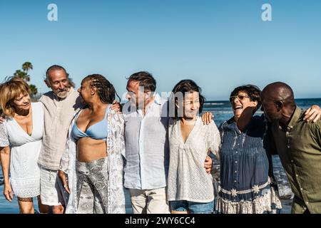 Fröhliche, multirassische Seniorenfreunde, die während der Sommerferien am Strand Spaß haben - verschiedene ältere Leute genießen den Urlaub Stockfoto