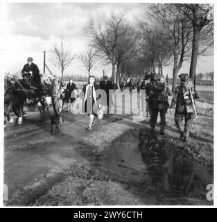 INFANTERIE-VORMARSCH AUF WANSSNM - während Truppen des Royal Norfolk Regt die Linie hinaufmarschieren, kommen Flüchtlinge aus dem Schlachtgebiet. Britische Armee, 21. Armeegruppe Stockfoto