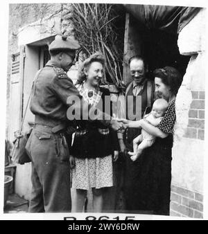 ARMEEOFFIZIER FUNGIERT ALS DORFARZT, WENN ER NICHT IM DIENST IST - nachdem er sich um das Baby einer Französin, die Familie, kümmert, kommen Sie zur Tür des Häuschens, um sich von der MO und Madamoiselle Dervis zu verabschieden. Britische Armee, 21. Armeegruppe Stockfoto