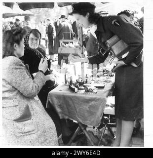 SONNTAG-MORGEN-MARKT IN BRÜSSEL: Diese Fotoserie in Brüssel zeigt einen typischen Sonntag-Morgen-Markt. Es ist sehr ähnlich wie unsere Petticoat Lane, wo man fast alles kaufen kann. Viele belgische Volksgruppen drängen auf dem Markt auf der Suche nach Artikeln wie Büchern, Eisenwaren, Fahrradteilen, Obst und vielen anderen Artikeln, die sie brauchen. In dieser Serie wird eine allgemeine Ansicht einer Straße gezeigt, in der der Brüsseler Schwarzmarkt weitergeführt wurde. Kein Schwarzmarkt, wie wir es verstehen, aber wo belgische Leute mit Lebensmitteln usw. versorgt wurden, war das von den Deutschen verboten. [DIESE FOTOS SIND ZU ERLEUCHTEN Stockfoto