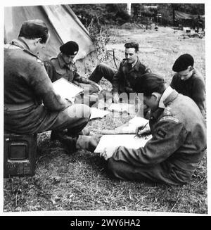 Eine CHURCHILL-CREW BEREITET SICH AUF DAS LEBEN Einer CHURCHILL-PANZERCREW VOR - Lt. Fathergill, der Geschwader-Führer, informiert seine Truppenführer. Britische Armee, 21. Armeegruppe Stockfoto