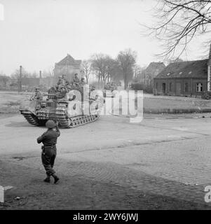 Churchill-Panzer der 6th Guards Armoured Brigade transportieren Fallschirmjäger der 17th Airborne Division durch Dorsten am 29. März 1945 während der Operationen in Nordwesteuropa. Stockfoto