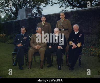 DER PREMIERMINISTER, DER RT HON WINSTON CHURCHILL, MIT SEINEN STABSCHEFS IM GARTEN DER DOWNING STREET 10, LONDON, 7. MAI 1945, von links nach rechts: Air Chief Marshal Sir Charles Portal, Field Marshal Sir Alan Brooke, der Premierminister und Admiral Sir Andrew Cunningham. Stehend, von links nach rechts: Generalmajor L C Hollis, Sekretär des Chiefs of Staff Committee, und General Sir Hastings Ismay, Generalstabschef des Verteidigungsministers. , Portal, Charles Frederick Algernon, Brooke, Alan Francis, Churchill, Winston Leonard Spencer, Cunningham, Andrew Browne, Hollis, Leslie Chasemore Stockfoto