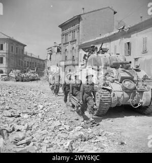 DIE BRITISCHE ARMEE IN ITALIEN 1945 – Stretcher-Träger passieren Sherman-Panzer in Portomaggiore, 19. April 1945. , Stockfoto