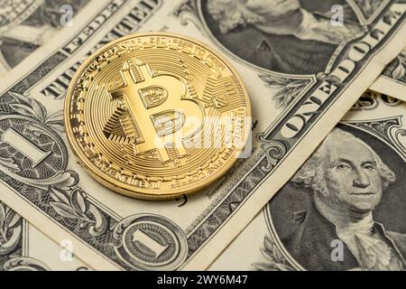 Goldene Bitcoin-Münze auf uns Dollar. Nahansicht. Stockfoto